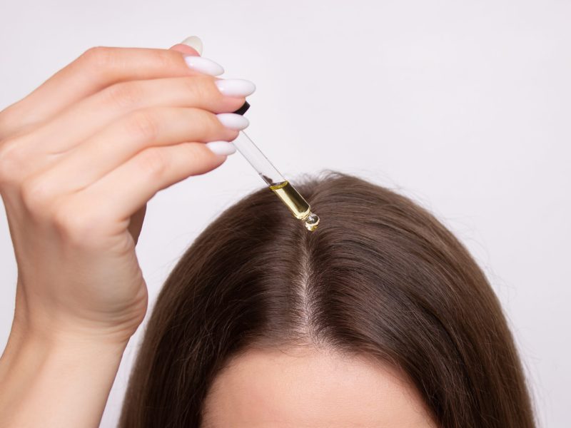 young-woman-applies-drop-oil-from-pipette-her-scalp-closeup-vitamins-keratin